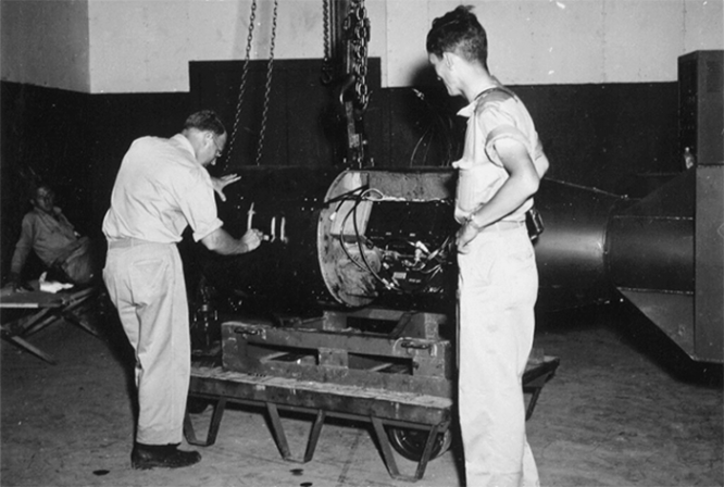 Американский инженер Фрэнсис Бирч маркирует атомную бомбу «Малыш» (Little Boy) надписью «L11». Август 1945 г.