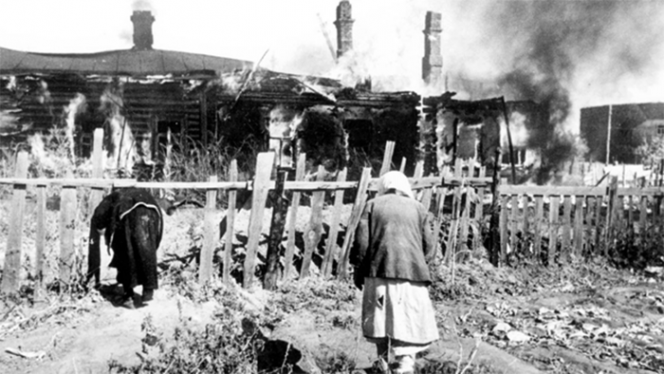 Пожилые жительницы города Ельня возле своих домов, горящих в результате боевых действий