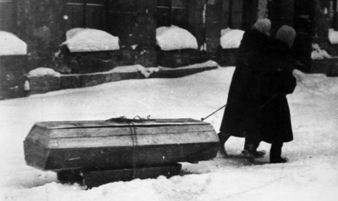 Блокада Ленинграда. Жители города везут на санках гроб с умершим