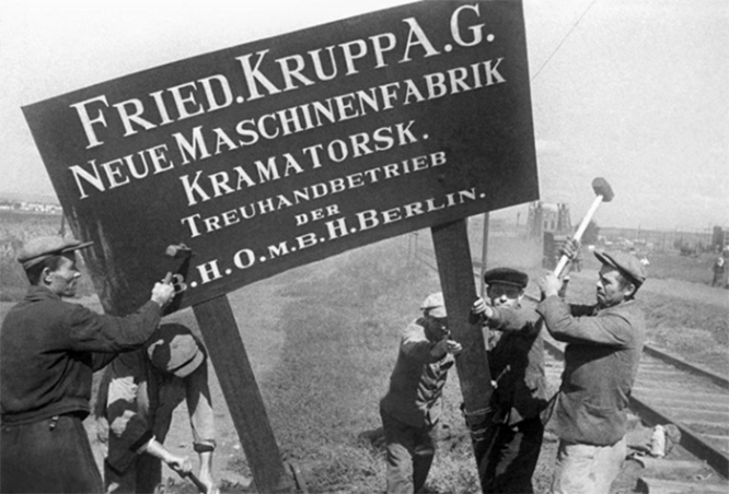 Рабочие Новокраматорского машиностроительного завода сносят немецкий указатель после освобождения Донбасса от немецкой оккупации. Краматорск, Донецкая область, 1943 г.