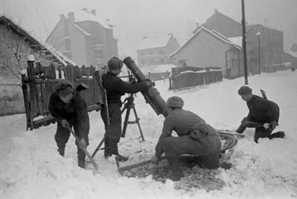 Советские минометчики устанавливают миномет на огневом рубеже в одном из районов Будапешта, февраль 1945 г.