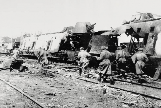 Красноармейцы бегут мимо разбитого немецкого бронепоезда во время боев на станции Раздельная под Одессой