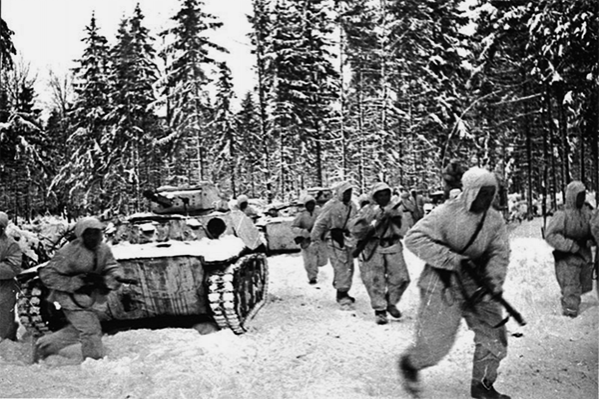 Танковый десант одной из частей 1-й Гвардейской мотострелковой Московской дивизии и колонна легких танков Т-40 в зимнем лесу во время битвы за Москву. Декабрь 1941 г.